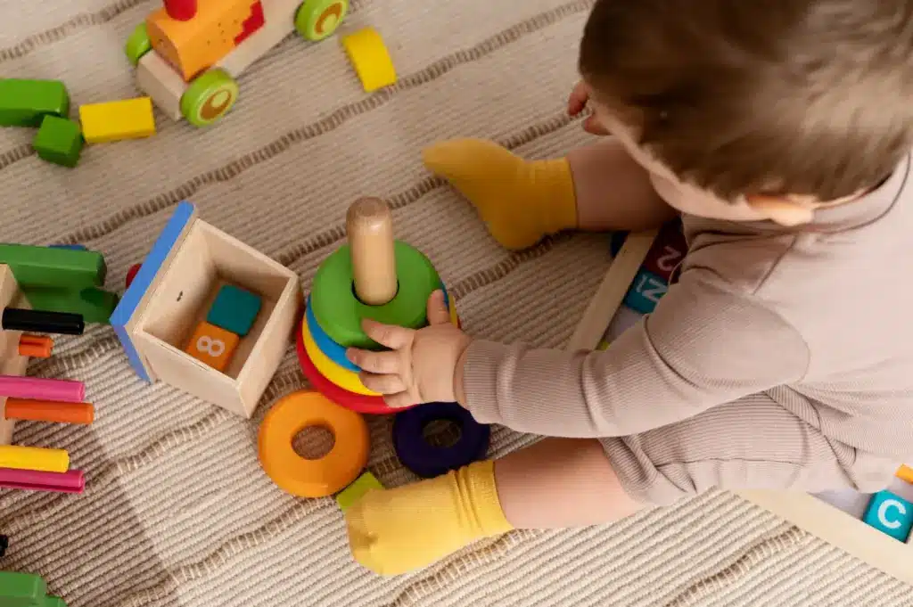 Niño jugando con piezas encajables en juegos para niños de 2 a 3 años en casa