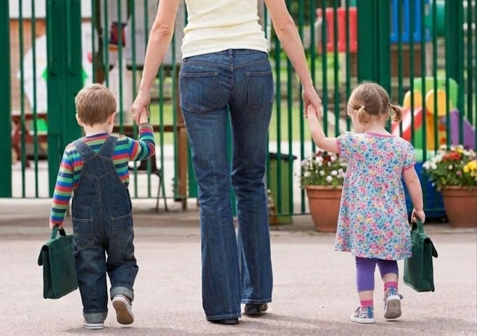 Familia llevando a niños a una de las tantas guarderías en Sevilla durante el periodo de matrícula infantil