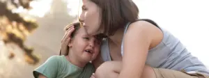 Madre acompañando a una niña durante una rabieta infantil de forma calmada y respetuosa